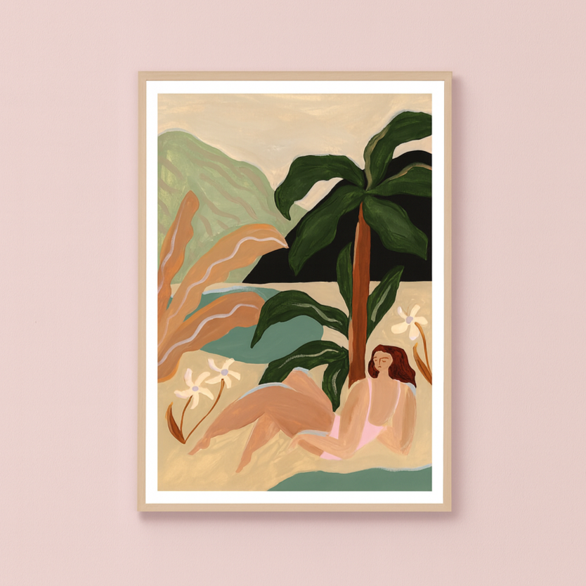Framed artwork of a woman by a palm tree on a beach with mountains in the background, on a pink wall.