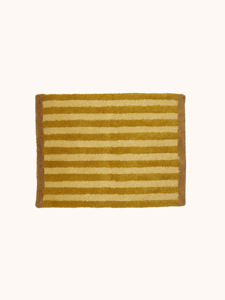 Bonnie and Neil stripe reversible bath mat in mustard, in a bathroom