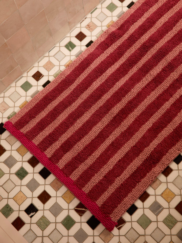 Bonnie and Neil stripe reversible long bath mat in burgundy, flat