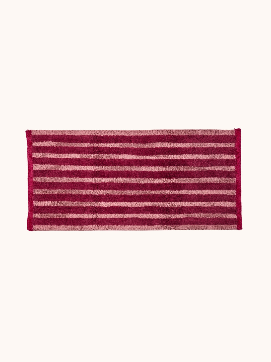 Bonnie and Neil stripe reversible long bath mat in burgundy, in a bathroom