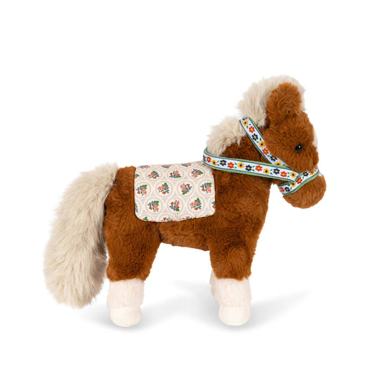 Stuffed horse toy with a saddle and bridle on a white background