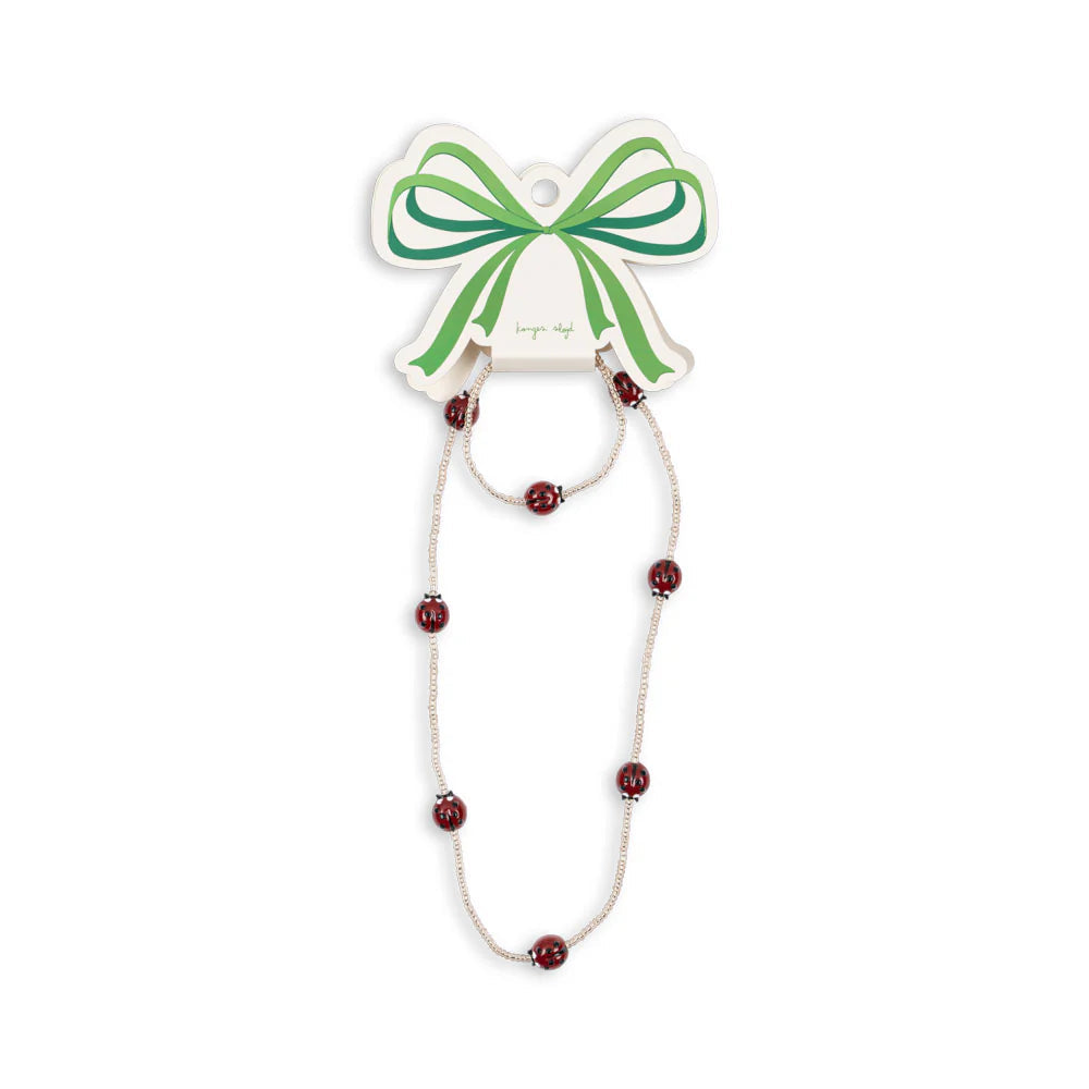Necklace with red lady bug beads on a white background