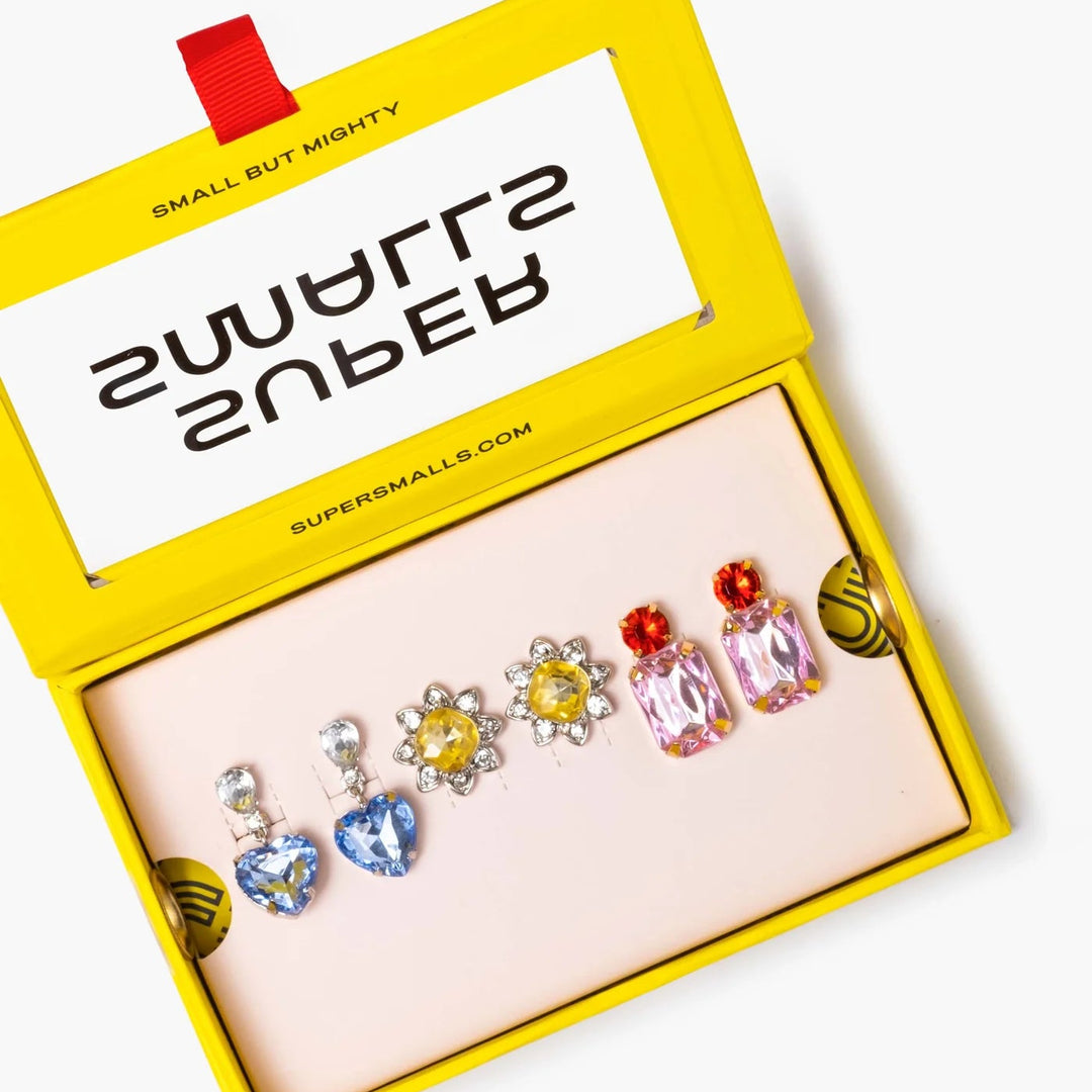 Set of colourful clip on earrings in a 'Supersmall' branded box on a white background